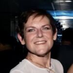 Sandra Vaccari_Photo Sandra has short dark hair and is wearing a white shirt