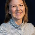 Meghan is wearing a striped button with jewels around the collar.