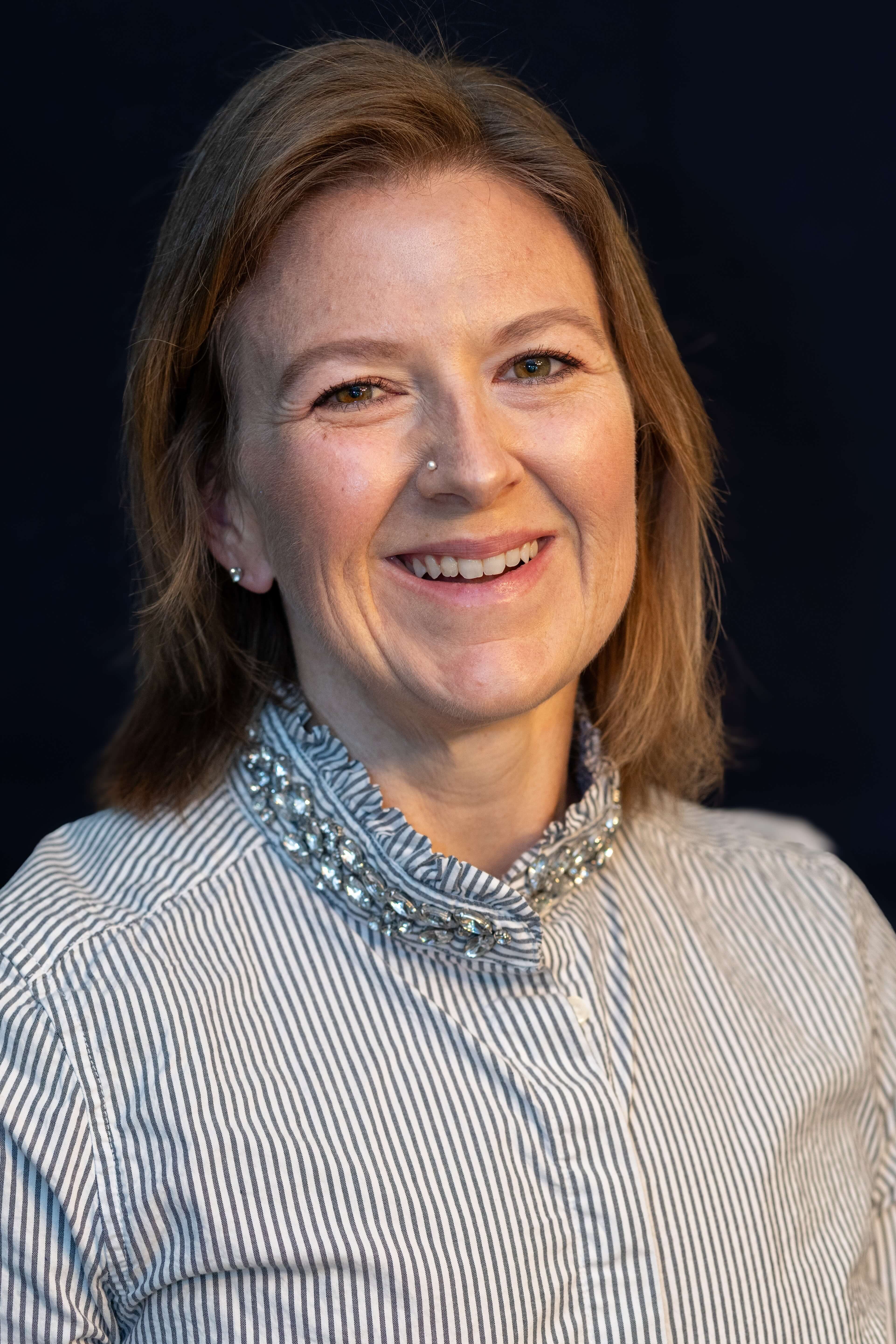 Meghan Simecek Photo Meghan is wearing a striped buttoned shirt with jewels around the collar.