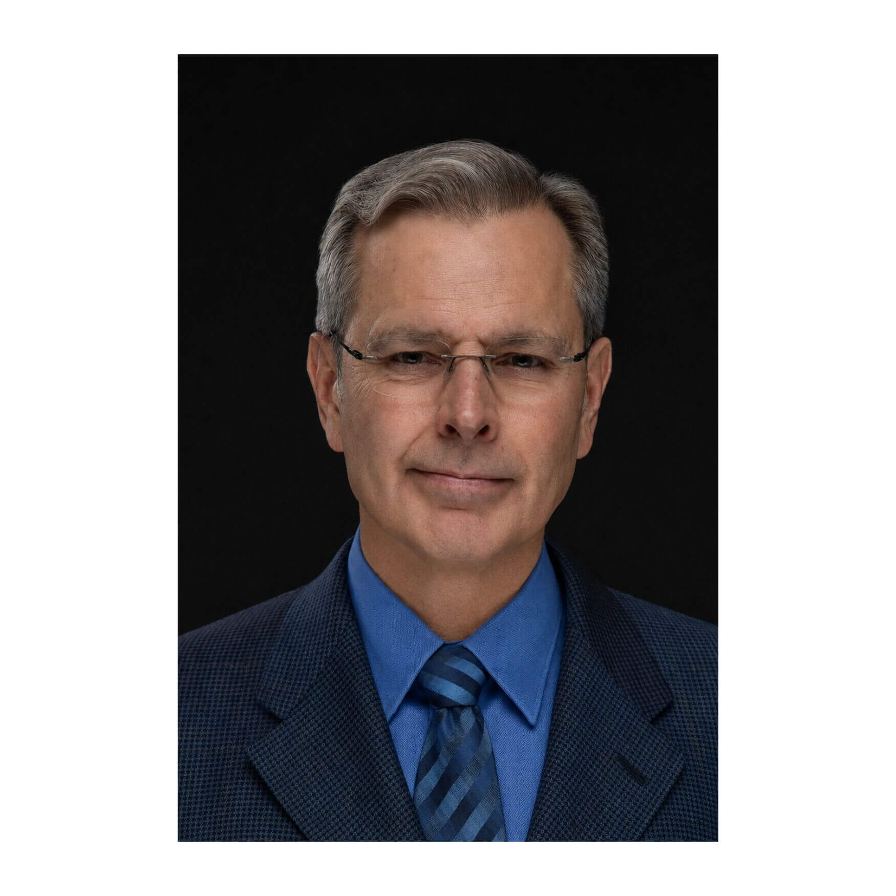 Rex Pace Professional headshot of Rex Pace, a man with glasses wearing a blue suit jacket and a blue striped tie against a black background.