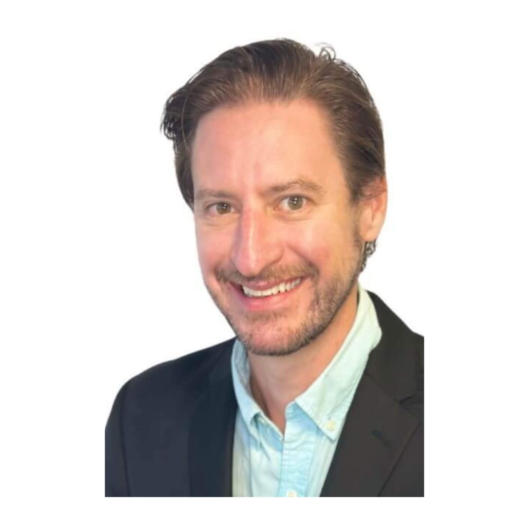 Headshot of Matt Lescher, a smiling man with short brown hair and a light beard and mustache, wearing a dark suit jacket and a light blue collared shirt against a white background.