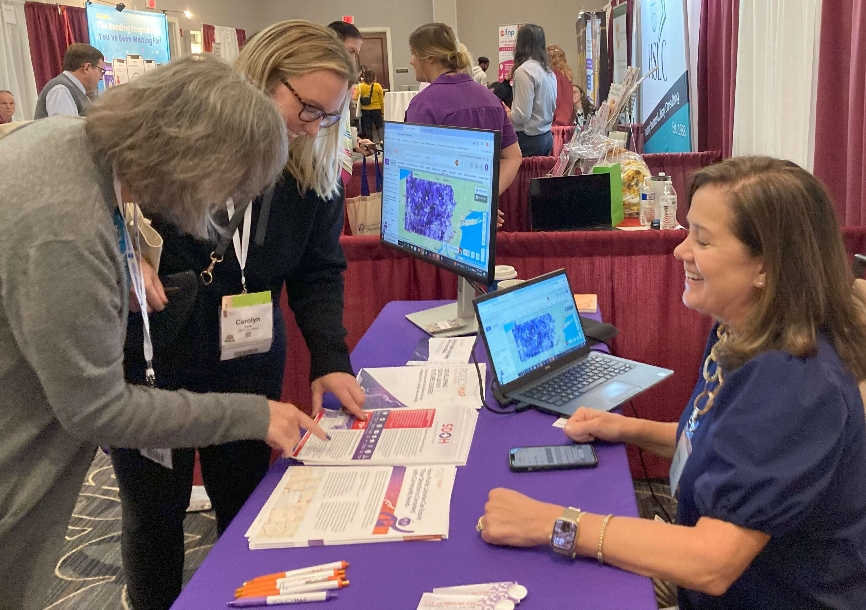 exhibits.general Image of conference attendees interacting with an exhibitor in the exhibit hall