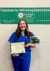 Cali Olshefski holds her DAISY Award® and sculpture on May 16, 2025.
