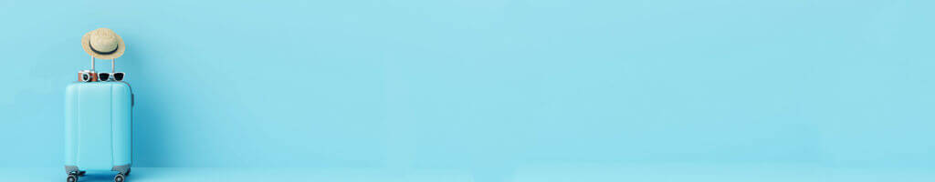 light blue luggage with sun hat on light blue background
