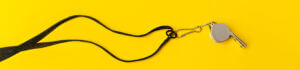 silver whistle on yellow background