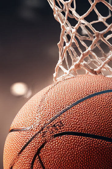 basketball under the net with stadium lights in the background