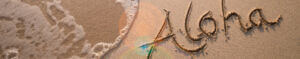 aloha written in the sand on a beach