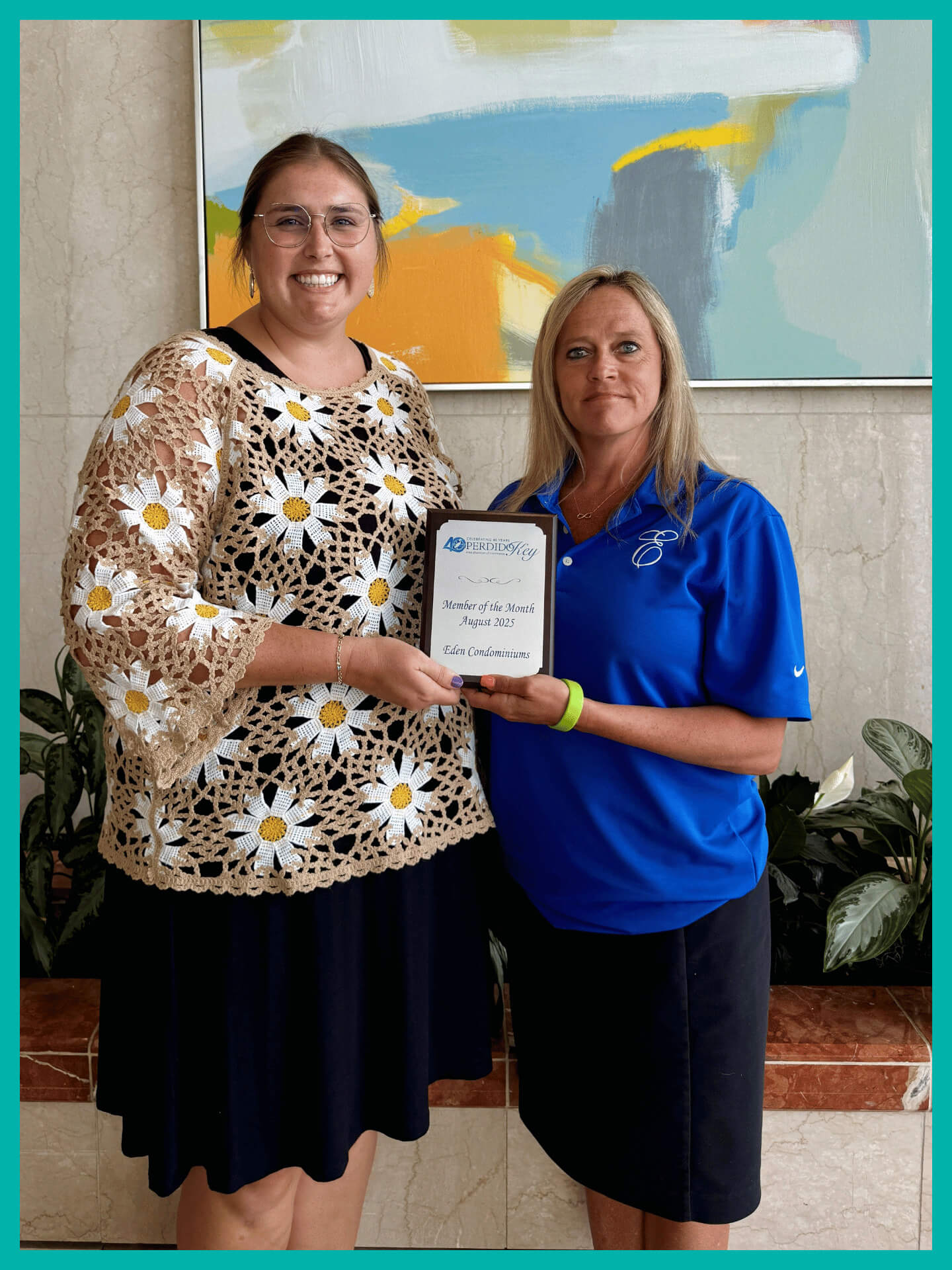 Photo of member of the month winner with plaque and staff member