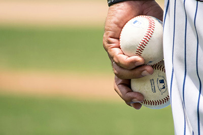 baseball pitcher holding two baseballs