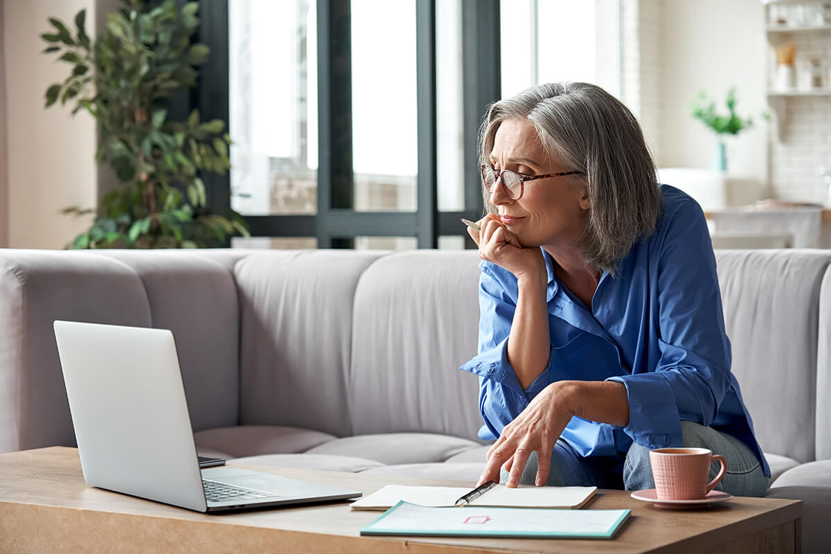 Senior older woman watching webinar on laptop working from home. Senior older woman watching webinar on laptop working from home.