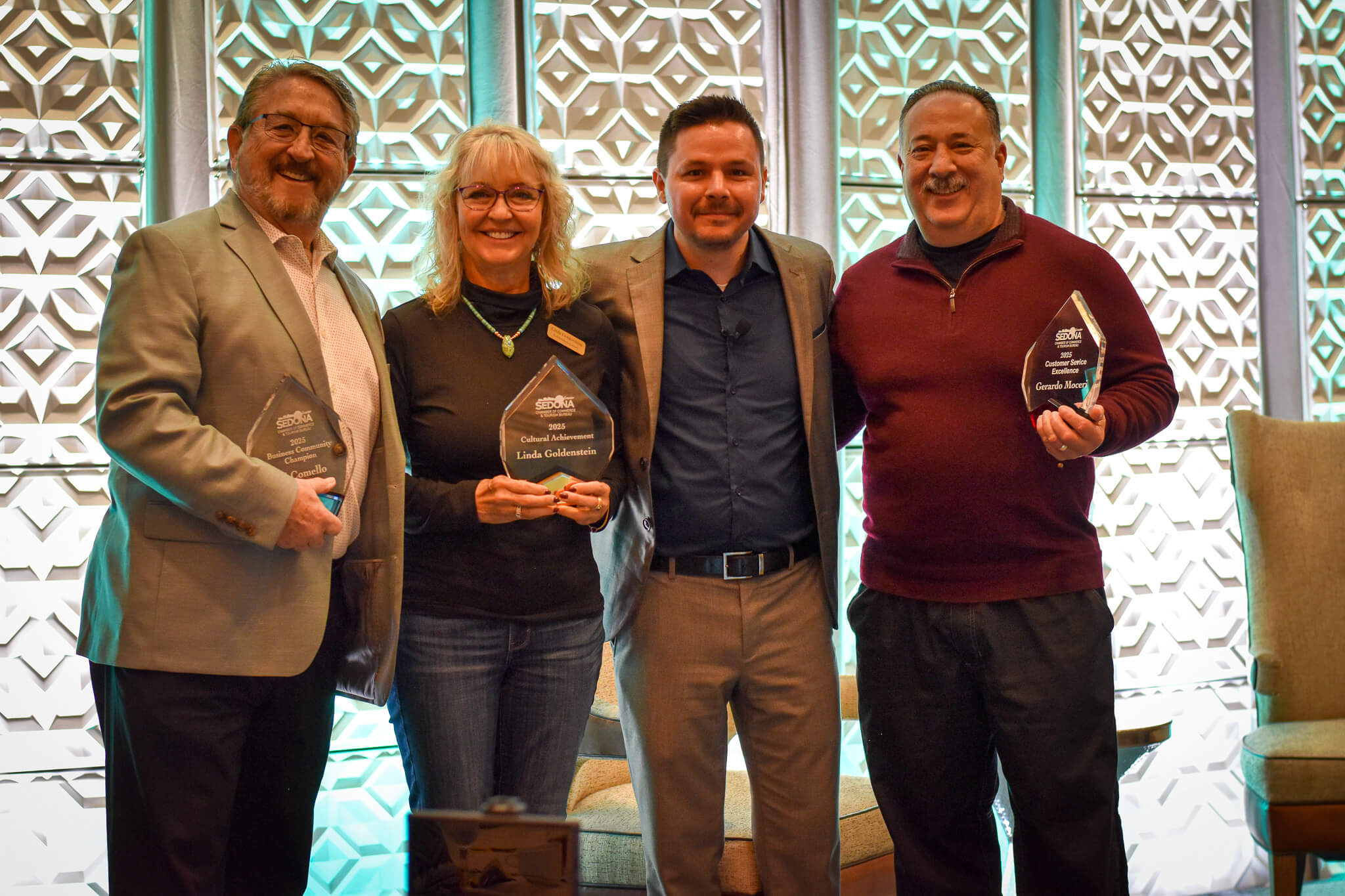 4 people group photo holding awards