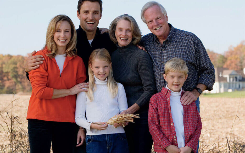 family standing in front of field