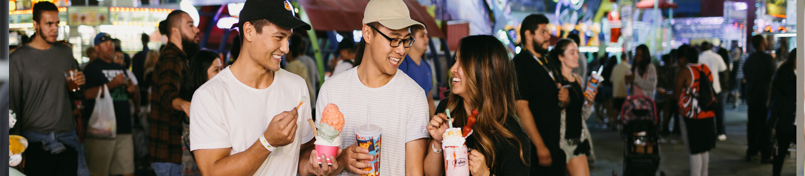 Play Three young people enjoy snacks in the ride funzone at Fairplex in Pomona CA