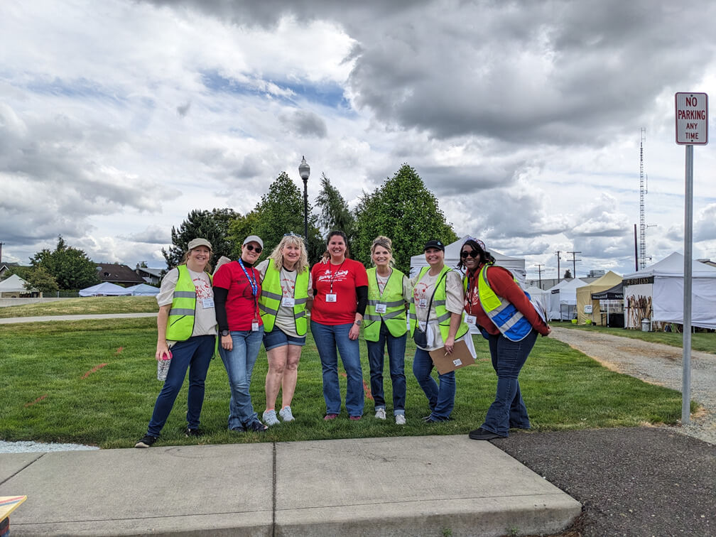 Berry Dairy Days volunteers standing arm in arm and smiling together at Skagit River Park in Burlington Washington