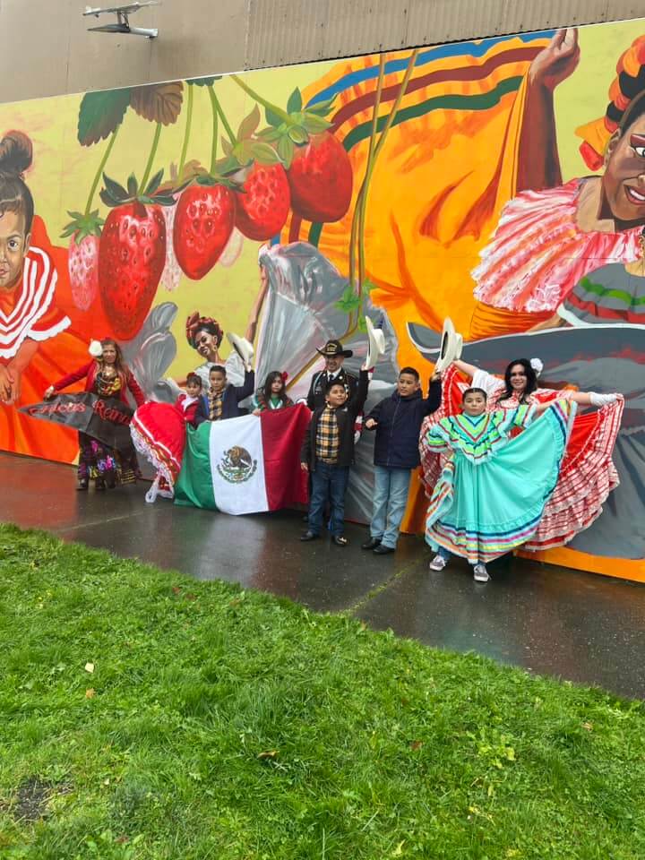 Chicas Reinas Dance Group stand in front of mural in downtown burlington wa