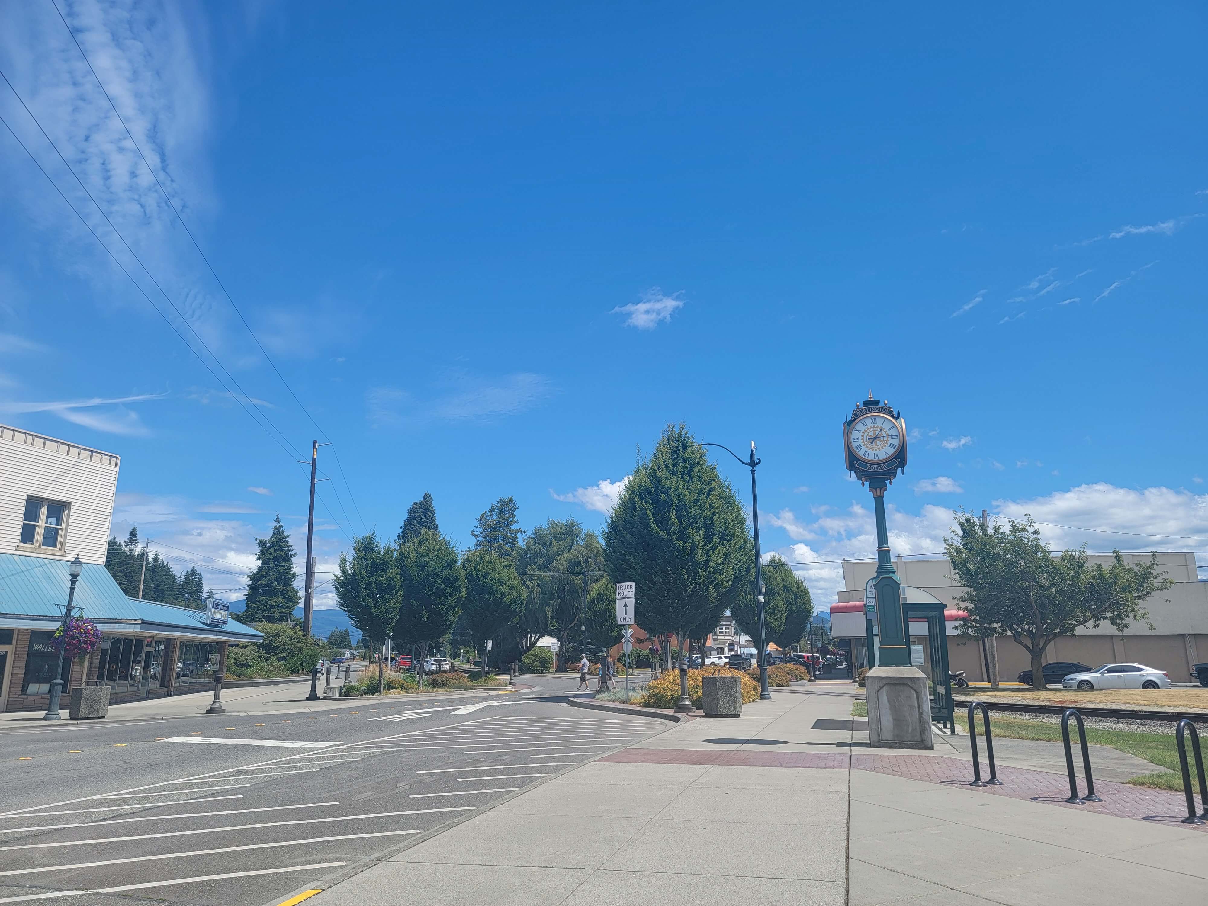 Fairhaven Avenue in Downtown Burlington, Washington, featuring the historic Rotary clock, storefronts, trees, and pedestrian-friendly streetscape.