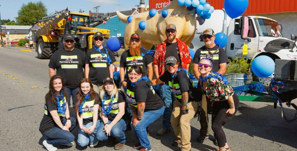 Skagit Farmers Supply Country Store team posing with their decorated parade vehicles before the Berry Dairy Days Grand Parade in Burlington, Washington.