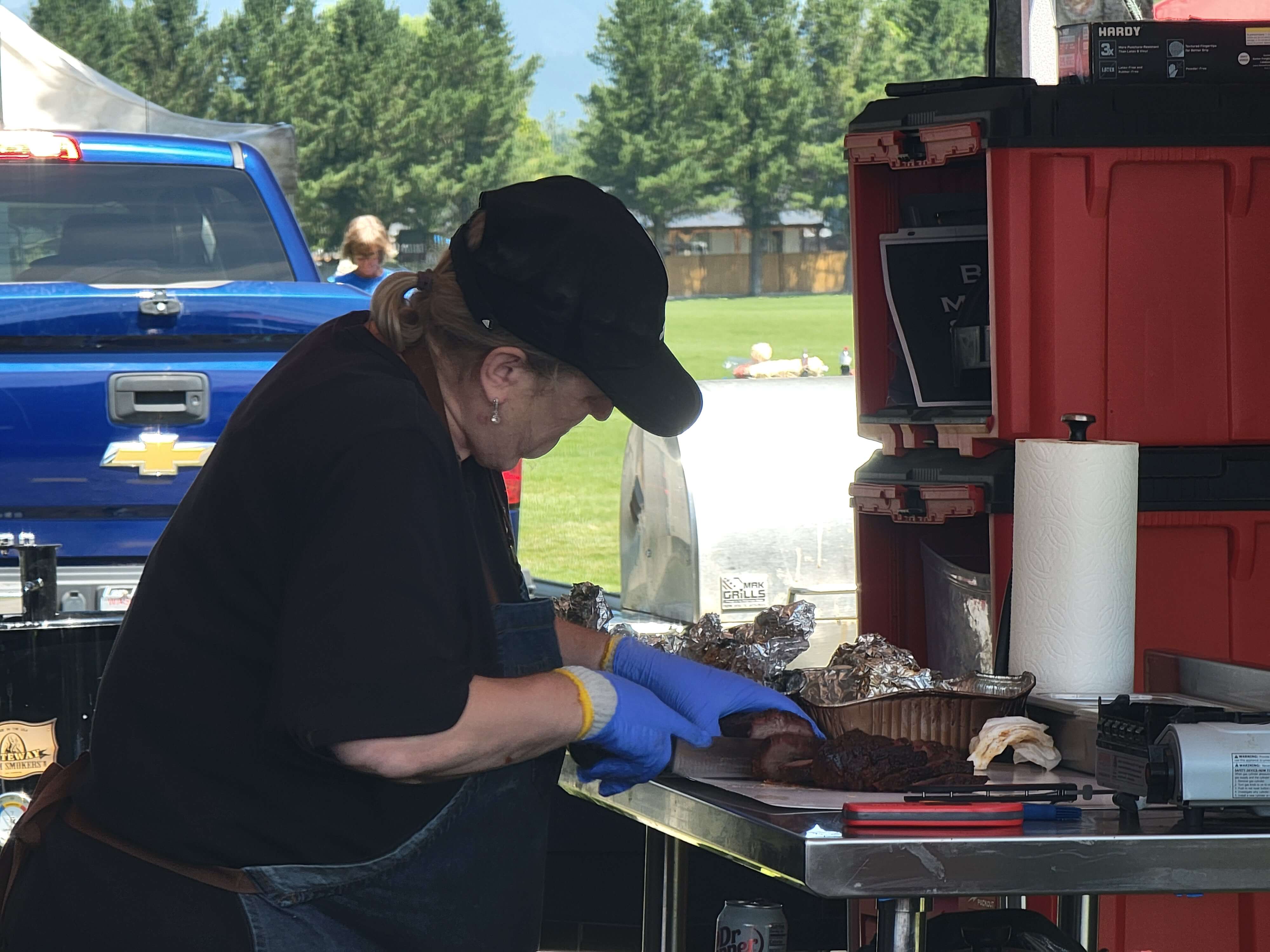 BBQ competitor preparing smoked meat during the Berry Dairy Days Smoke & Grill BBQ Competition.