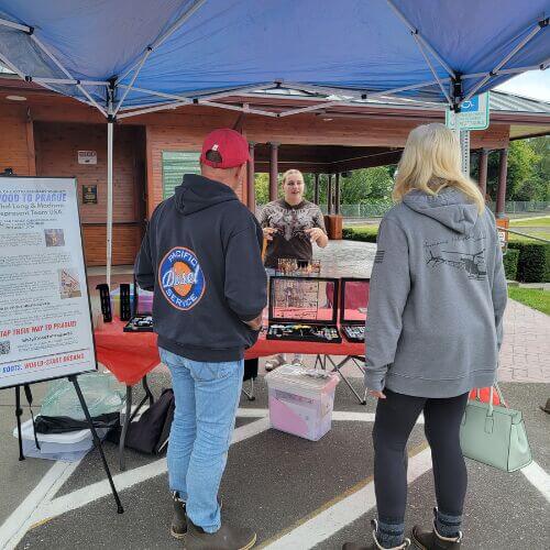 Shoppers visit a local jewelry booth at the Burlington Artisan & Agricultural Market near the Burlington Visitor Information Center.