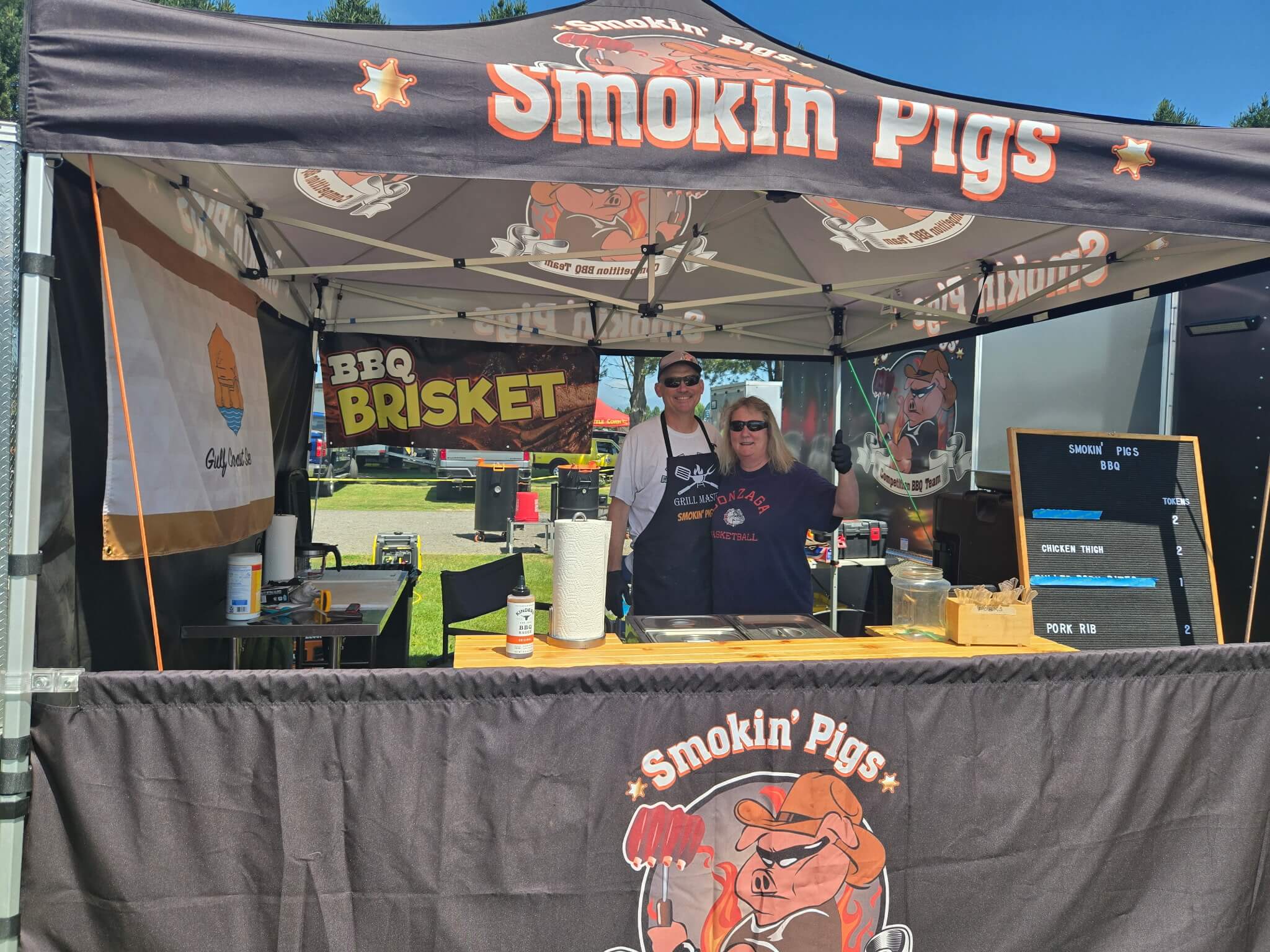 Smokin’ Pigs BBQ team booth serving samples during the Berry Dairy Days Smoke & Grill BBQ Competition.