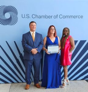 Steph Rees holding her IOM certificate at the U.S. Chamber of Commerce after completing Institute for Organization Management