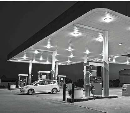 White car at a gas station at night