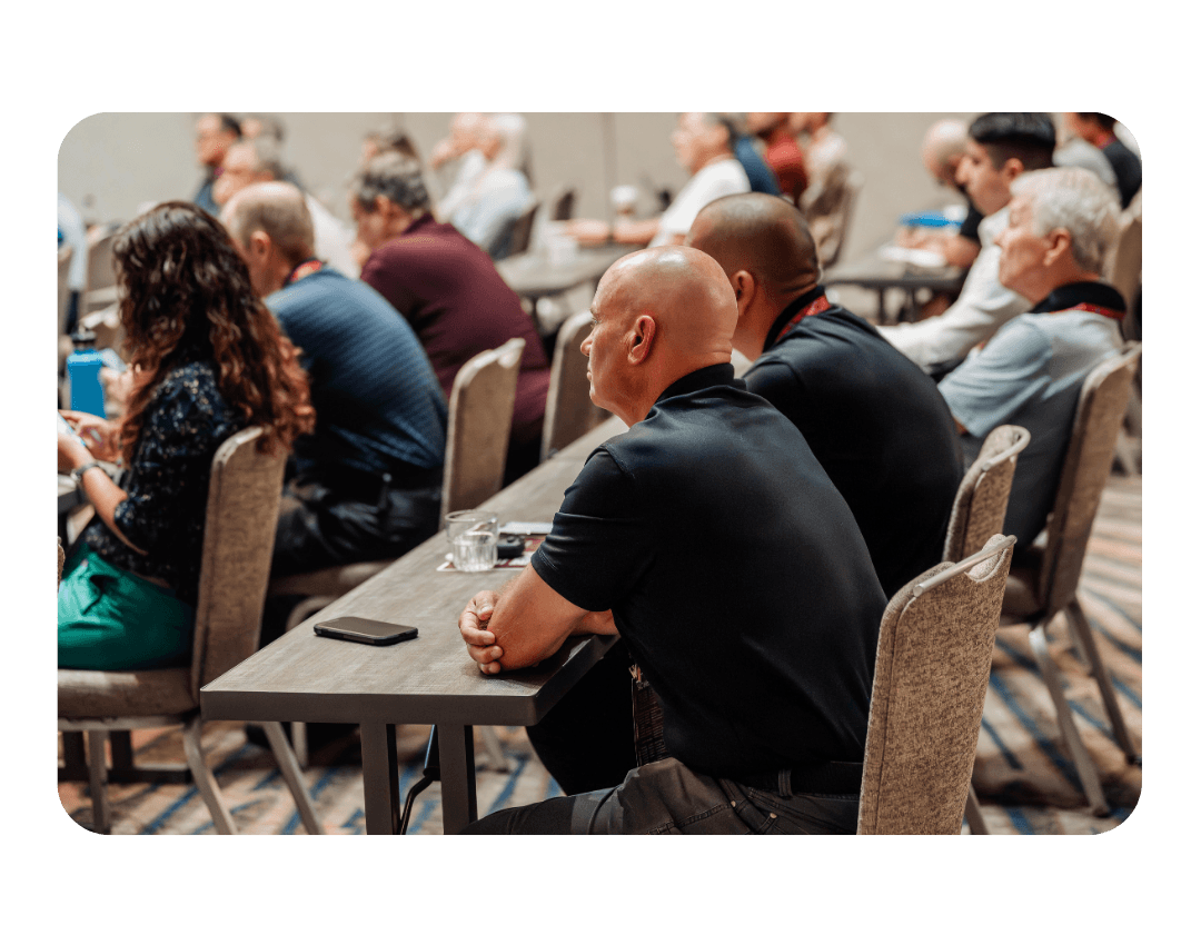 row of people sitting and listening to a presentation