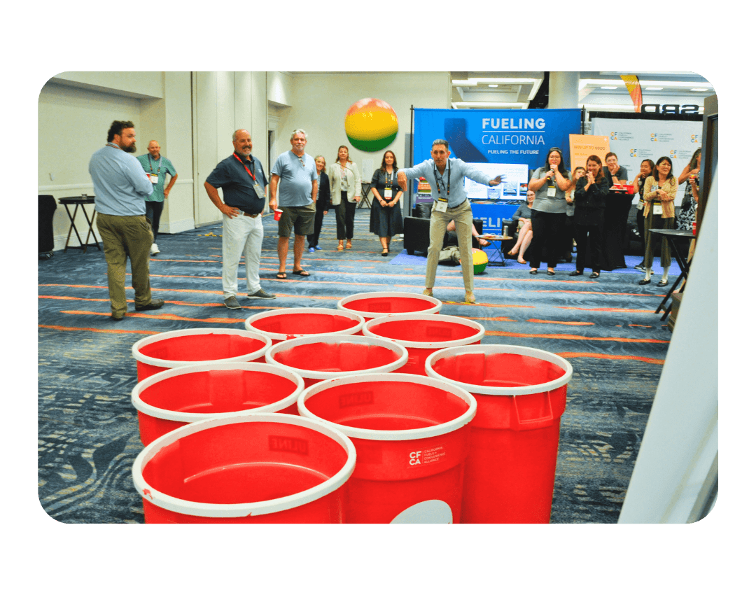 Man throwing beach ball in giant beer pong cups