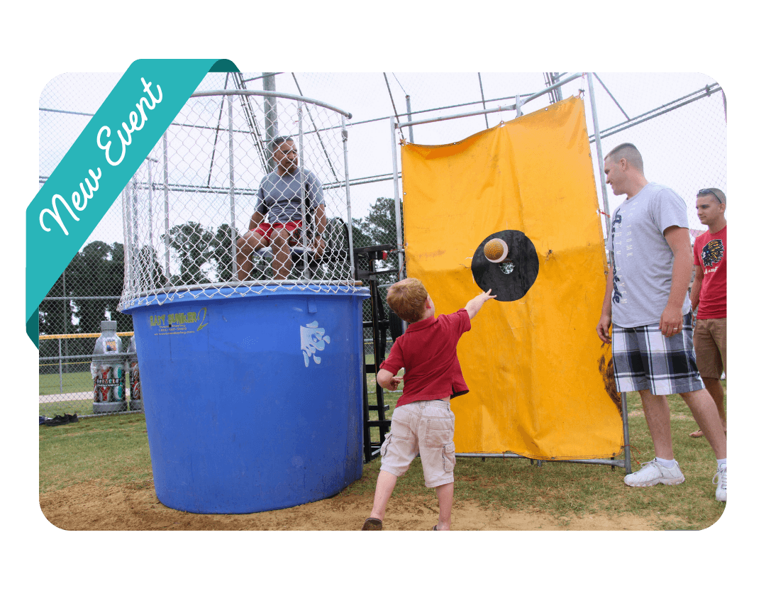 a small child throws a ball at the dunk tank bullseye