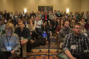 A packed room full of conference attendees.
