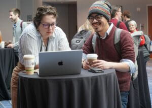 Two people looking at computer at NICAR Conference