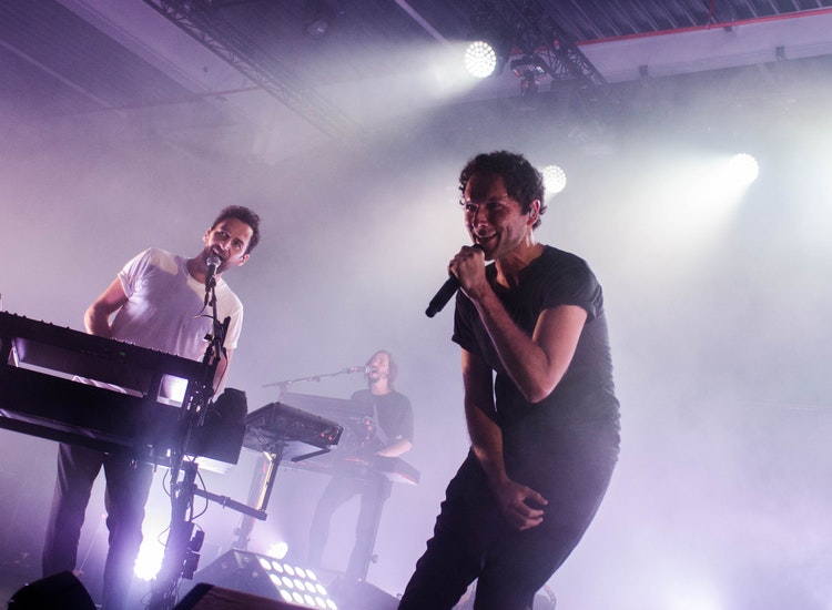 singers on stage with mics and keyboard