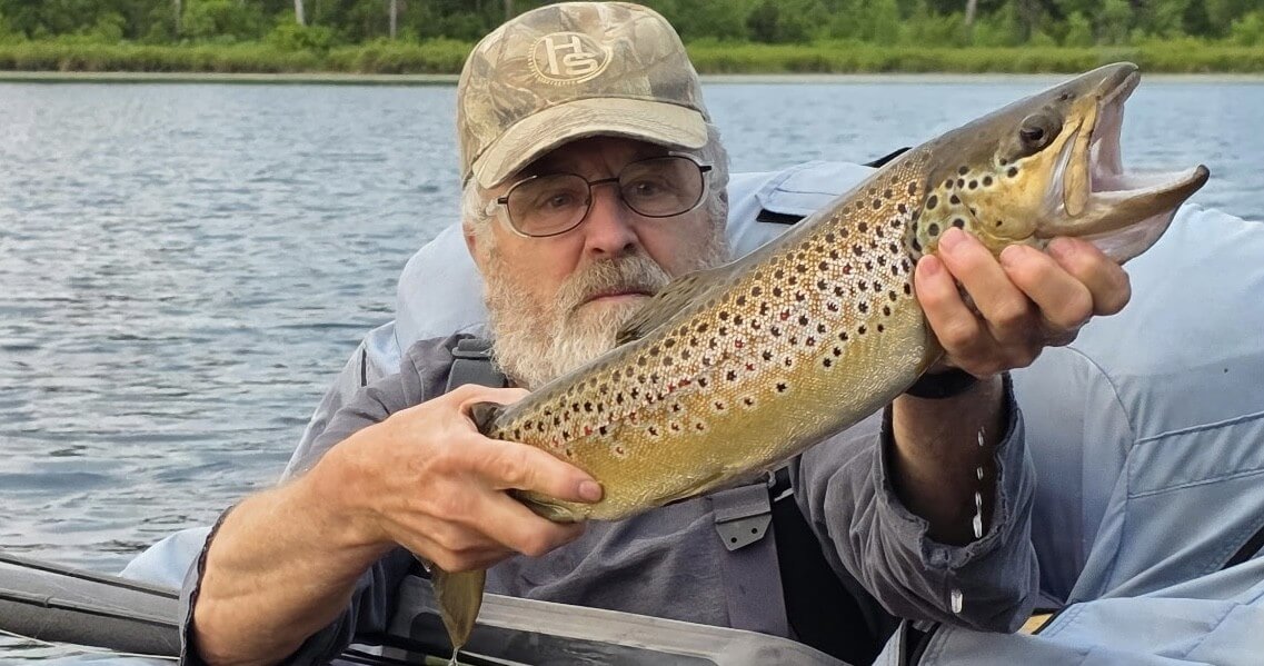 An angler with a large brown trout