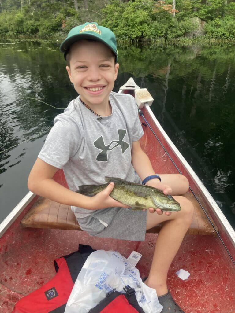 A young angler shows off a smallmouth bass