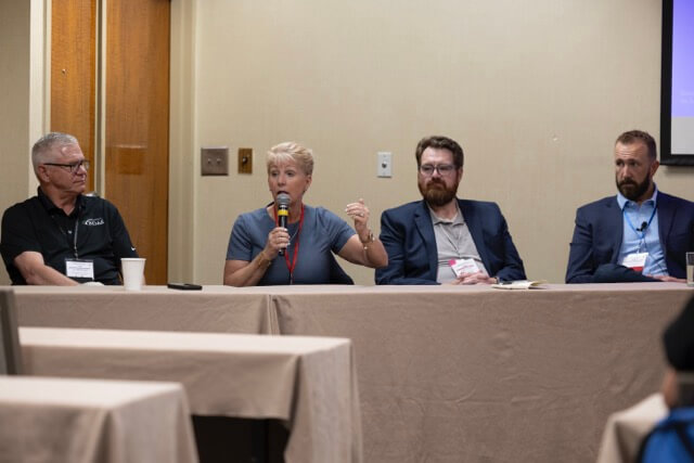 group of people seated at front of room speaking