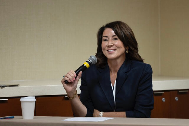 woman speaker seated with microphone