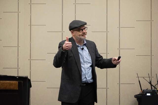 speaker man giving thumbs up while talking