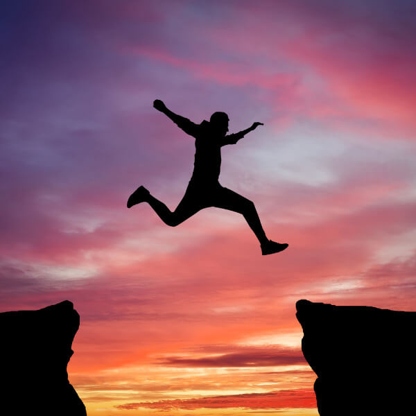 person jumping in air at sunset