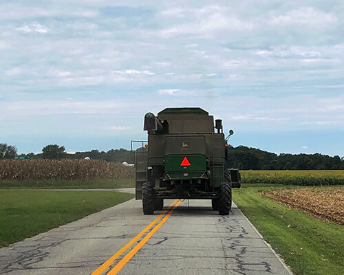 farm equipment with slow vehicle sign on back