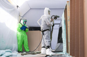 person spraying insulation