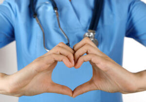 Healthcare worker with hands forming a heart