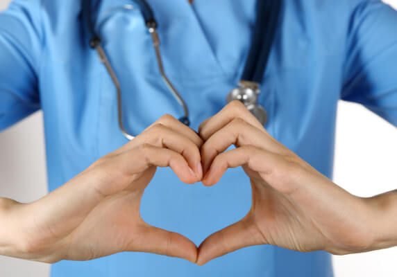 Healthcare worker with hands forming a heart