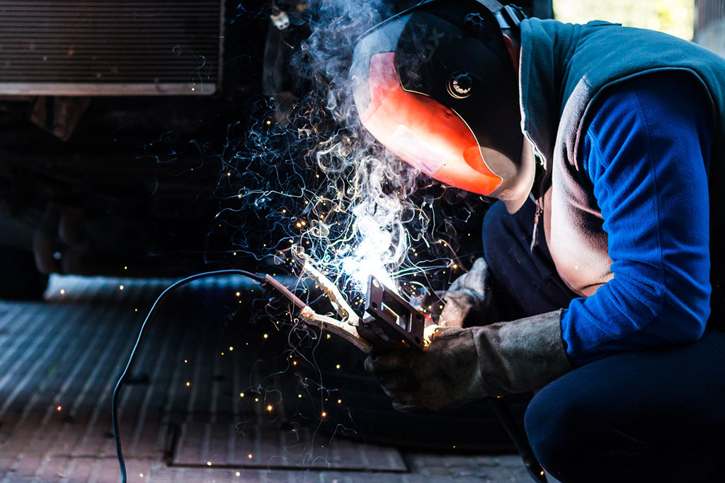 skilled mechanic welding some custom parts of his car.