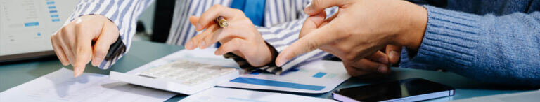 hands reviewing calculator and papers