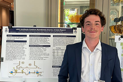 IMG_1953_2nd-place-poster_web man at annual conference standing next to display