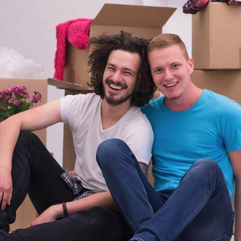 2 smiling people sitting down