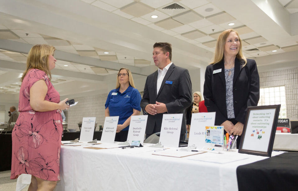 people standiung behind table with clipboards