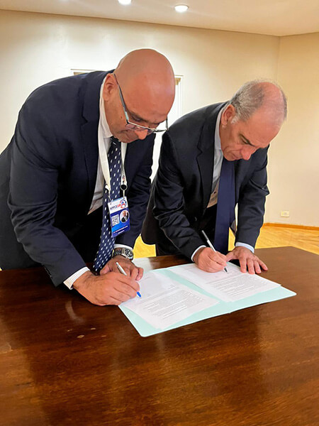two men signing documents