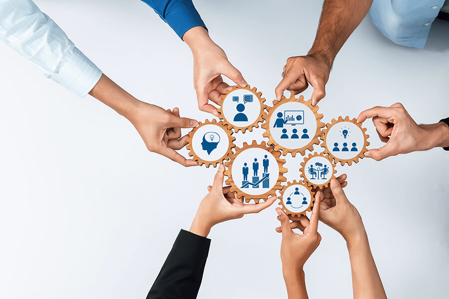 Collaborative Teamwork Concept with Diverse Hands Supporting Business and Innovation Through Graphic Gear Icons on a Light Background