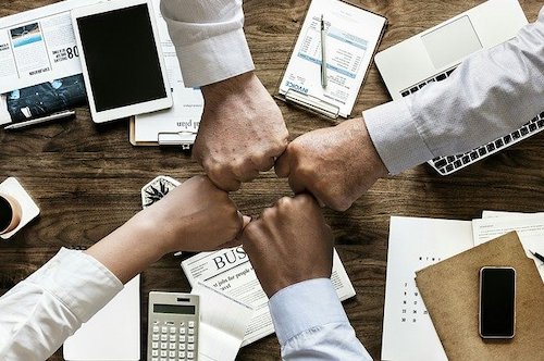 4 hands together representing teamwork